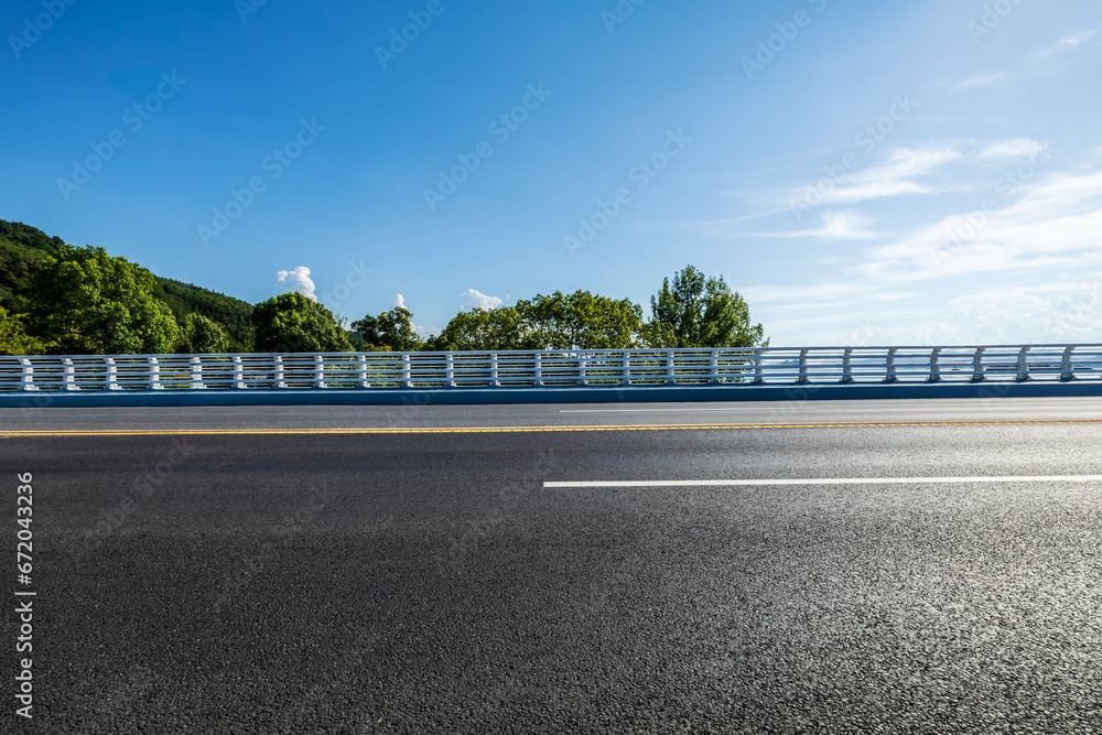 Fototapeta premium Highway and green tree landscape under blue sky