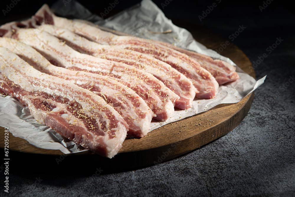 raw pork belly on a wooden board