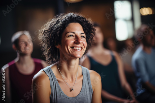 woman smiling in yoga class with people in the background. relax  © Uwe