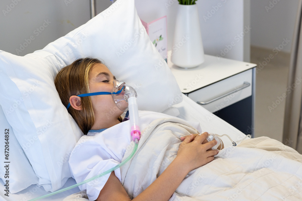 Caucasian girl patient with drip and wearing oxygen mask asleep in hospital bed Caucasian girl patient with drip and wearing oxygen mask asleep in hospital bed