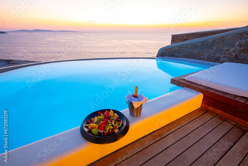 Fototapeta Naklejka Na Ścianę i Meble -  Infinity swimming pool in the villa at sunset time, Mykonos, Greece