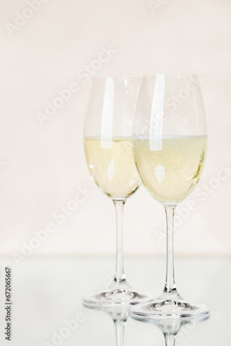 Two champagne glasses on a beige