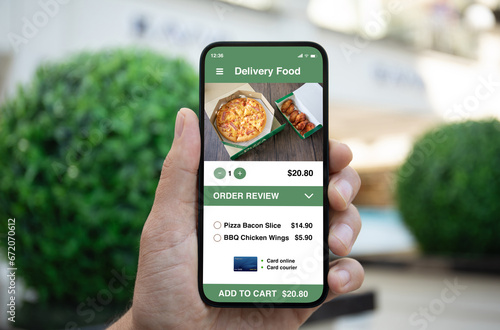 Man hand holding phone with food delivery app on screen