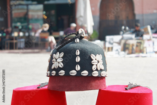 Moroccan black fez hat decorated with shells of cowries in a street market , in Morocco.