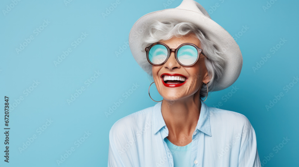 Closeup face of senior business woman standing against blue background with copy space. Portrait of successful woman in blue shirt feeling confident and looking at camera. Happy mature woman face with