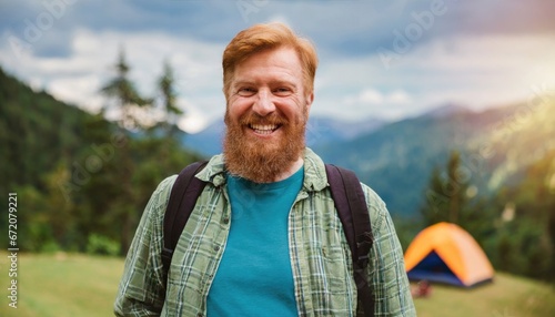 Happy older bearded man standing in nature park outdoors and laughing. Smiling active mature senior traveler looking at camera advertising camping tourism. Close up face front portrait