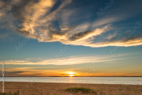 Landscape of beautiful sunset with clouds on the route and then on the beach with palm trees around © Emanuel