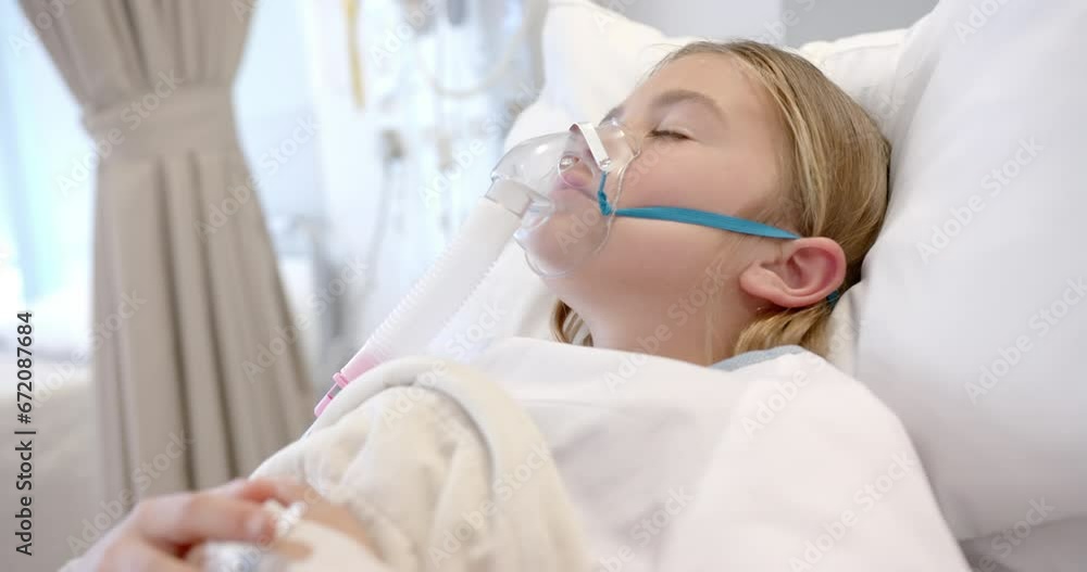 Caucasian girl patient in oxygen mask asleep in hospital bed, slow motion Caucasian girl patient in oxygen mask asleep in hospital bed, slow motion