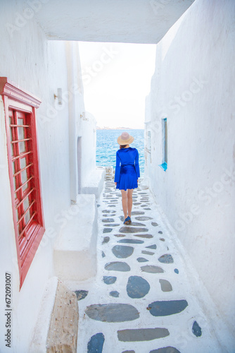 Woman in blue dress at the Streets of old town Mykonos during a vacation in Greece, Little Venice Mykonos Greece © Kyrenian