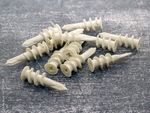 White self drilling wall anchor plugs isolated on a concrete background