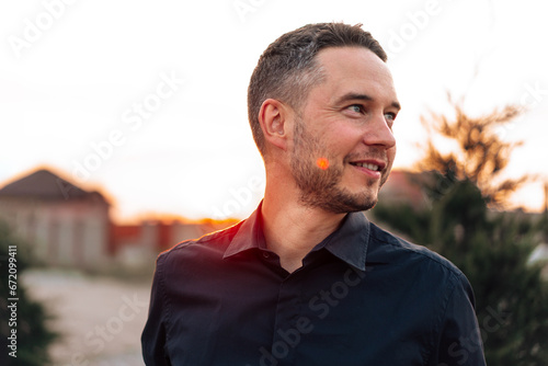 Portrait of handsome successful man standing outdoors