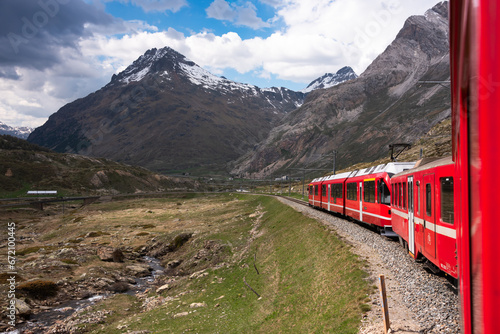 Red train going in beautiful landscape in Switzerland