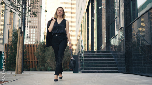 Pretty 30s business woman take walk. Sexy lady boss city stroll. Attractive 40 years old businesswoman. Successful top manager step. Confident beautiful girl gait. Fun joy person wear black job suit.