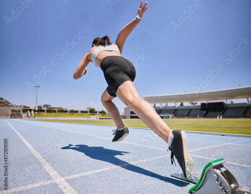 Woman track runner, start running and sprint training for race exercise, fitness workout and using starting blocks for speed. Competitive sports athlete, fast sprinter and girl exercising for cardio photo