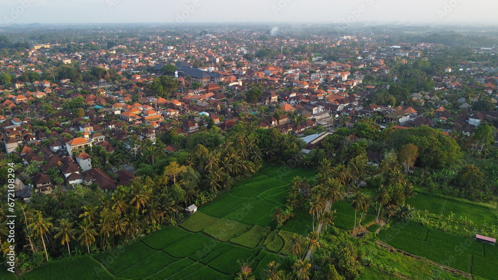 Aerial view of a paddy rice field backgrounded by Ubud town in Bali, Indonesia.