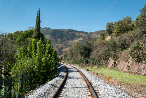 Entre montanhas, pinhal e muitas rochas, uma linha de comboio com uma curva à frente em Portugal photo