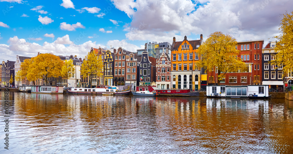Amsterdam, Netherlands. Panoramic view of channels in amsterdam city. Dancing houses. River Amstel. Old european landmark. City autumn fall landscape with blue sky clouds