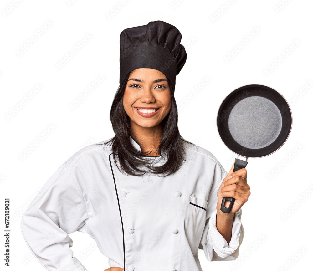 Young Filipina chef holding pan by handle showing a copy space on a palm and holding another hand on waist. Young Filipina chef holding pan by handle showing a copy space on a palm and holding another hand on waist.