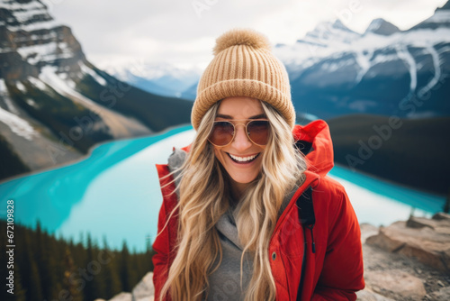 Happy smiling girl, with a backpack and jacket relaxing in the winter nature. Peyto Lake, Alberta