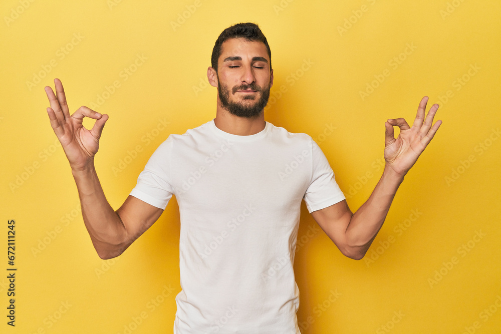 Young Hispanic man on yellow background relaxes after hard working day, she is performing yoga. Young Hispanic man on yellow background relaxes after hard working day, she is performing yoga.