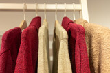 selective focus, fine wool sweaters hung on hangers in a store
