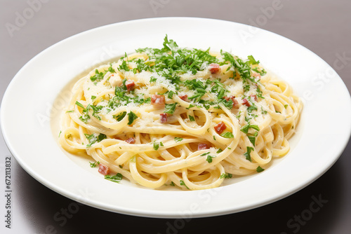  A white plate holds spaghetti carbonara, garnished with a sprinkle of parsley and grated Parmesan cheese