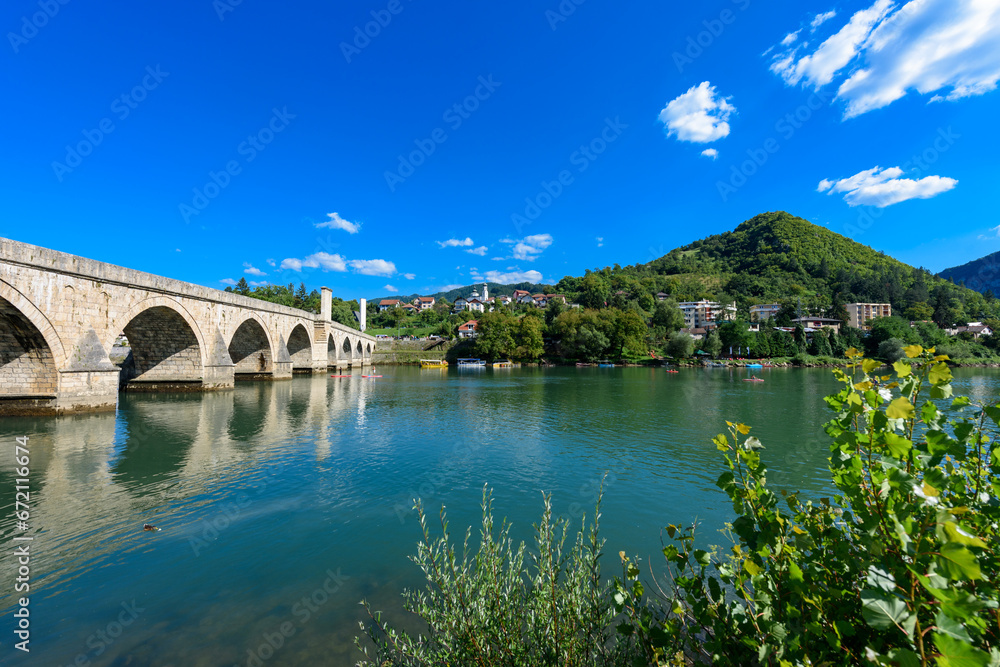 Obraz premium Visegrad, Bosnia and Herzegovina - August 13, 2023: Famous bridge on the Drina in Visegrad, Bosnia and Herzegovina. Mehmed Pasa Sokolovic Bridge on Drina River