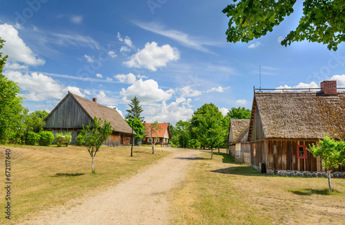 Small cozy houses. Wooden ancient buildings. Summer village and vacation. Farm bio products.