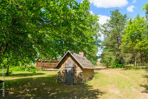 Small cozy houses. Wooden ancient buildings. Summer village and vacation. Farm bio products. © Sergey T..
