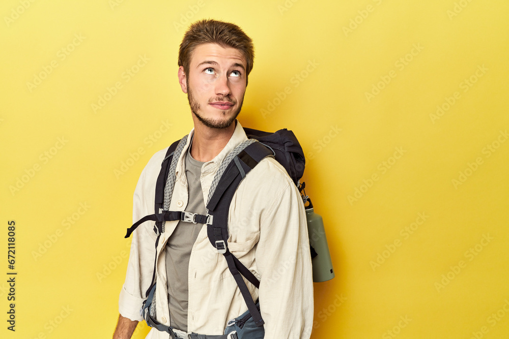 Traveler with mountain gear and yoga mat dreaming of achieving goals and purposes Traveler with mountain gear and yoga mat dreaming of achieving goals and purposes