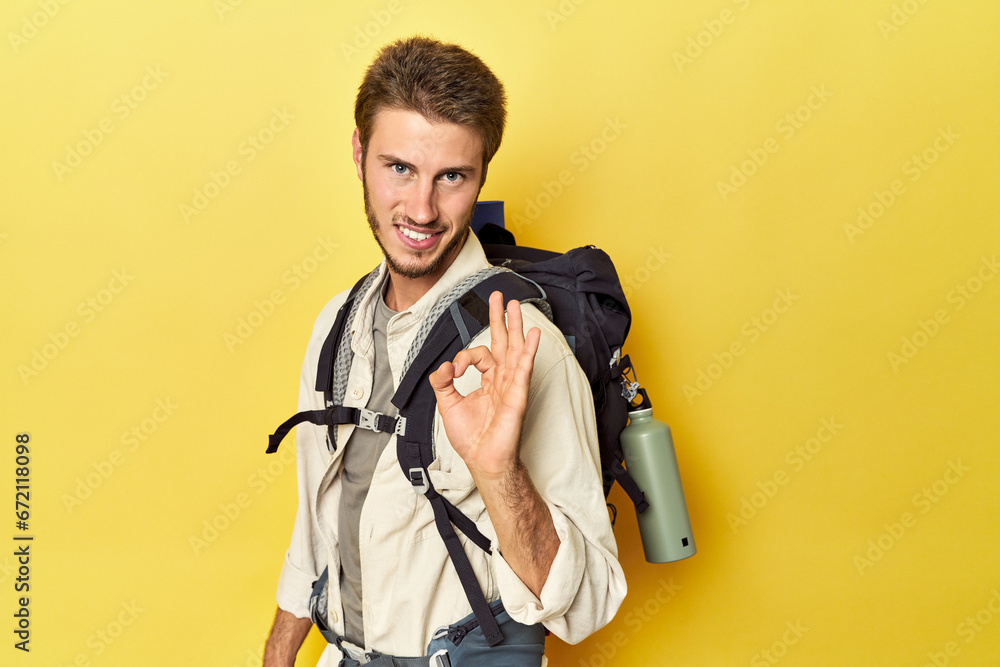 Traveler with mountain gear and yoga mat cheerful and confident showing ok gesture. Traveler with mountain gear and yoga mat cheerful and confident showing ok gesture.
