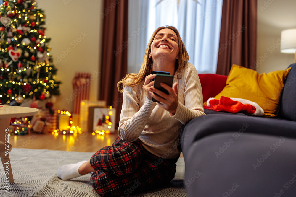 Young woman enjoying her online Christmas shopping Young woman enjoying her online Christmas shopping