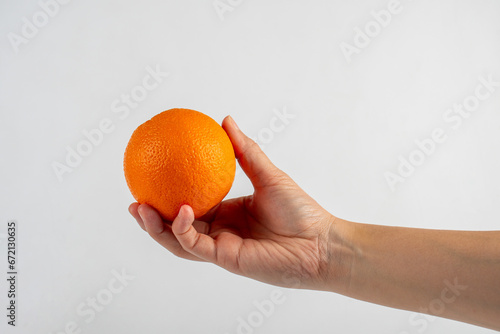 Hand holding orange isolated on white background