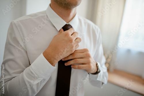 A young businessman is getting dressed for a meeting. The beginning of a new working week.