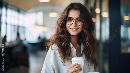 Fantastic long-haired french lady in glasses looking absent with grin, holding container of coffee