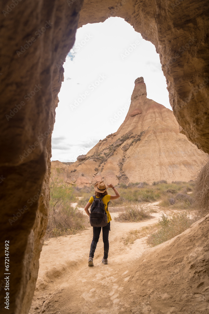 Woman in hat walking along a path in the desert Woman in hat walking along a path in the desert
