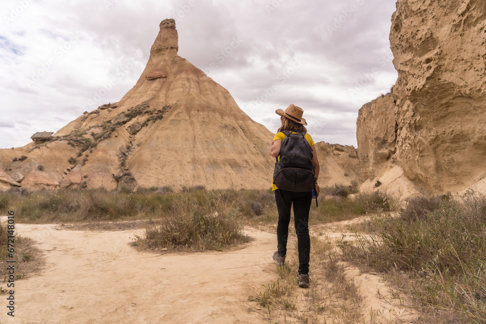 Woman walking along a path in an arid national park Woman walking along a path in an arid national park