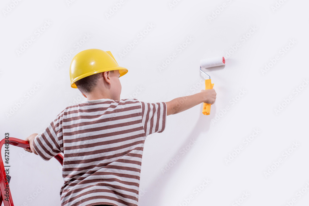 Cute boy with a paint roller. Happy kid helps parents to paint wall. New house for family. Cute boy with a paint roller. Happy kid helps parents to paint wall. New house for family.