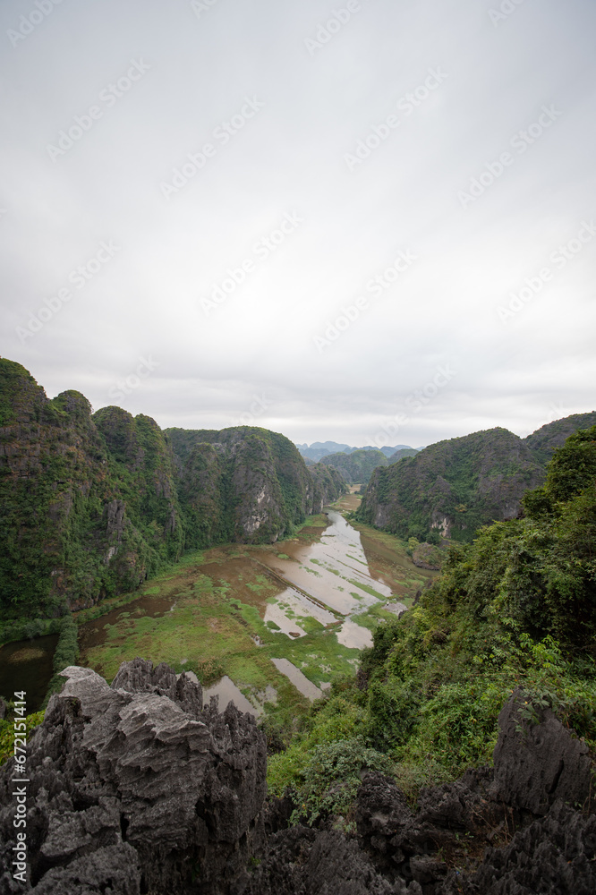 Stunning panorama of Ngo Dong River and the paddy fields below from the Ngoa Long Mountain in Ninh Binh, Vietnam.