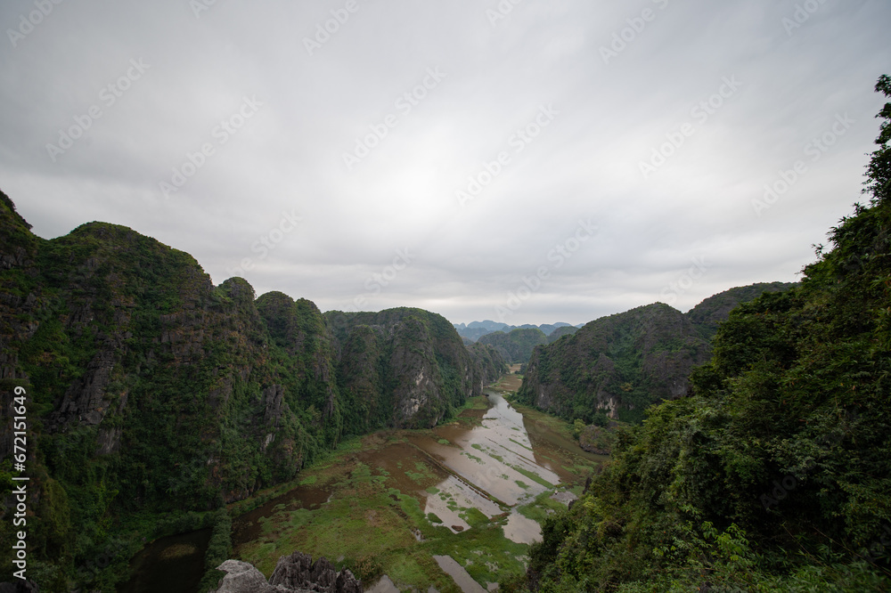 Stunning panorama of Ngo Dong River and the paddy fields below from the Ngoa Long Mountain in Ninh Binh, Vietnam.