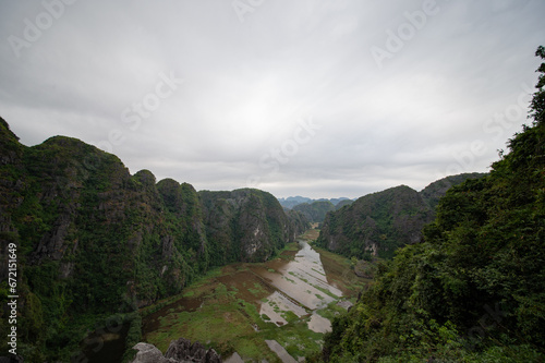 Obraz na płótnie Stunning panorama of Ngo Dong River and the paddy fields below from the Ngoa Long Mountain in Ninh Binh, Vietnam. w salonie