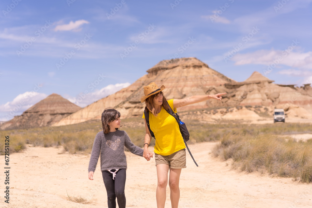 Mother and daughter holding hands strolling for a national park