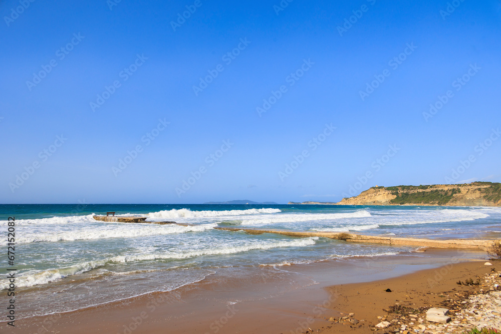 Coast of the island of Corfu near the town of Arillas under blue skies and heavy seas