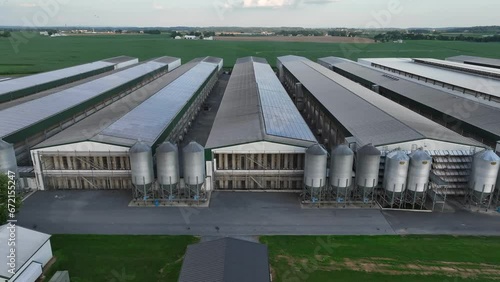 Chicken farm in USA. Aerial truck shot of factory farm with large chicken house barns with solar panels on roof. photo