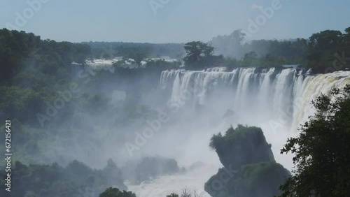 Iguazu Falls Waterfall in Argentina, Dramatic Distant View of Waterfalls in Picturesque Jungle Greenery Landscape, Amazing Splash From Water Falling off Huge Cliffs in Beautiful Sunny Conditions photo