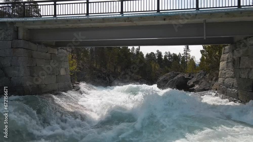Srone footage following along fast flowing river, under bridge in Norway, Billingen photo