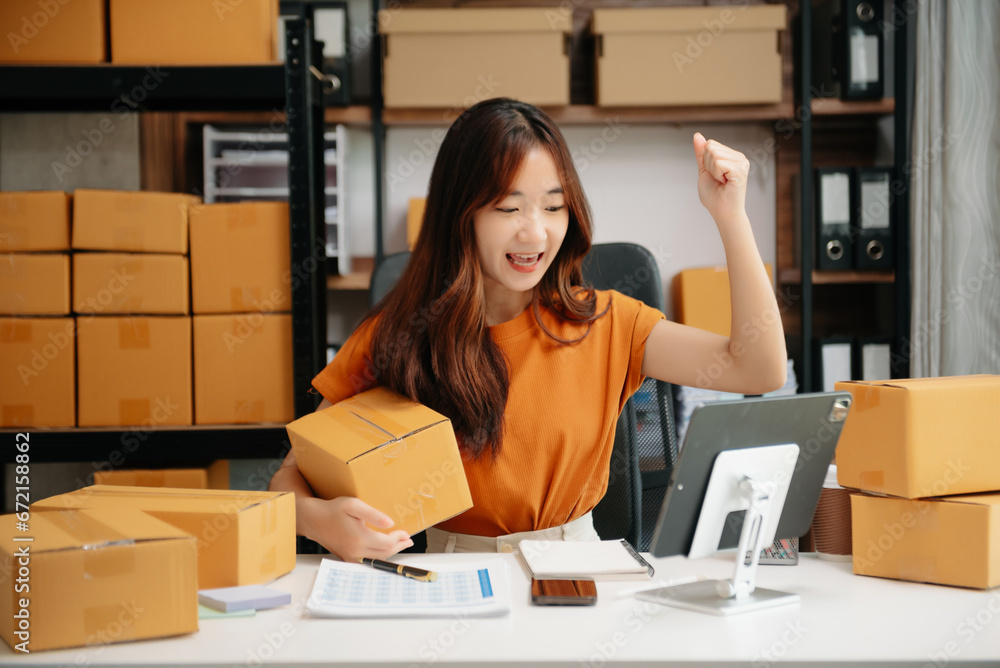 Young woman prepare parcel box and standing check online orders for deliver to customer on tablet, laptop Shopping Online concept. Young woman prepare parcel box and standing check online orders for deliver to customer on tablet, laptop Shopping Online concept.