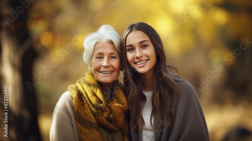 Grandmother and granddaughter walk in a park in nature in autumn on a sunny day, connection between generations, spending time with family photo