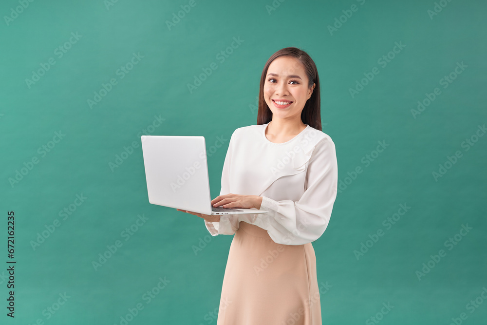 Young happy smiling woman in casual clothes holding laptop and sending email to her best friend Young happy smiling woman in casual clothes holding laptop and sending email to her best friend