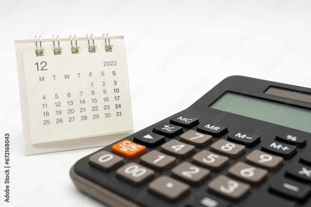 calculator and calendar on white background for money and debt management concept. Economic calculation before 2024. calculator and calendar on white background for money and debt management concept. Economic calculation before 2024.